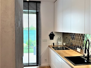 Niewielki dom na Maślicach - realizacja projektu - Mała otwarta z salonem biała czarna z zabudowaną lodówką z nablatowym zlewozmywakiem kuchnia jednorzędowa z oknem, styl nowoczesny - zdjęcie od DekoDeko