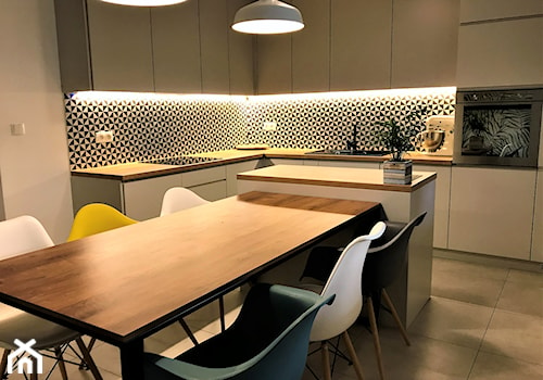 Kuchnia z roślinną tapetą i wielkim stołem - realizacja projektu - Średnia biała jadalnia w kuchni, styl nowoczesny - zdjęcie od DekoDeko