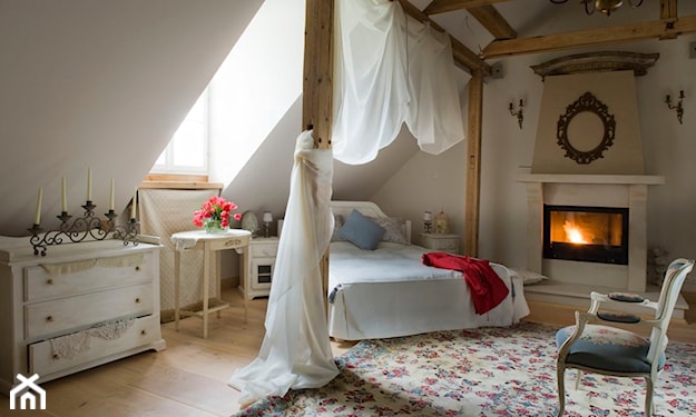 sypialnia na poddaszu, drewniane belki stropowe, beżowy dywan w kolorowe kwiaty