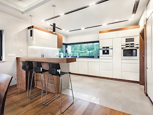 Kuchnie - Duża otwarta z salonem biała z zabudowaną lodówką kuchnia w kształcie litery u z oknem, styl nowoczesny - zdjęcie od Max Kuchnie