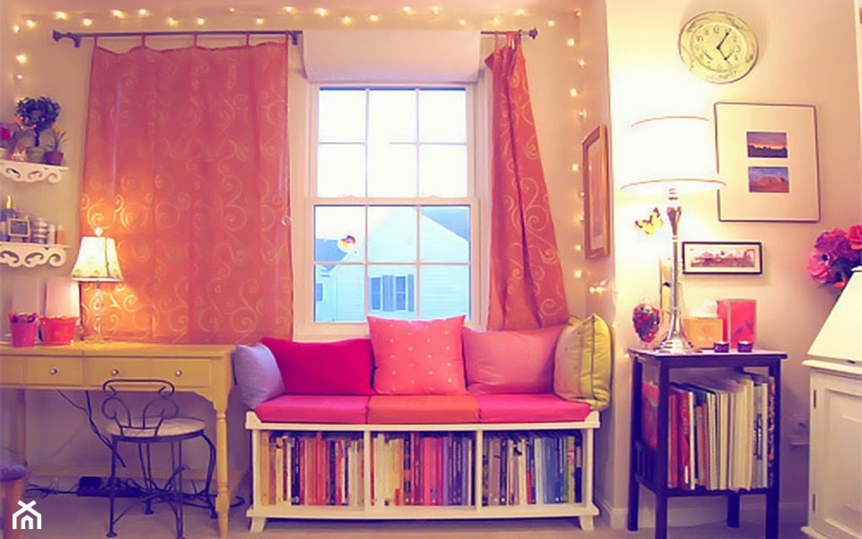 żółte biurko, różowe zasłony, różowe poduszki, metalowe krzesło, siedzisko z półką na książki